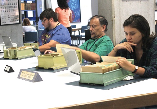 Foto de personas en la Sala de Consulta revisando ficheros